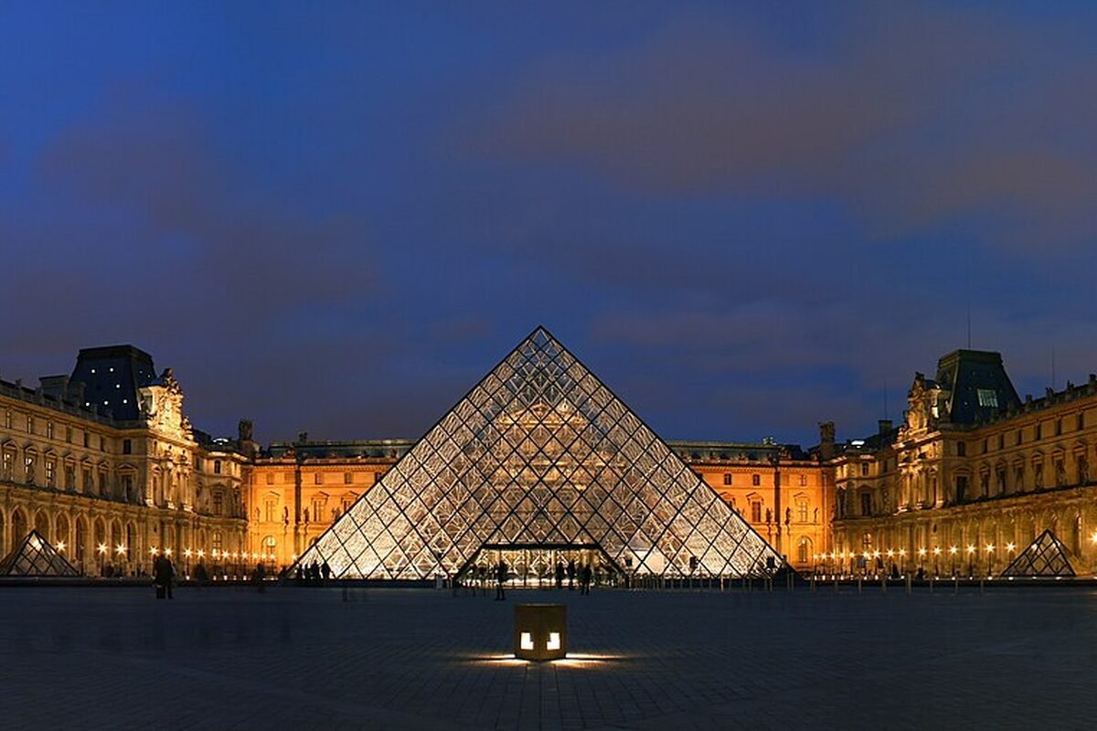 The Louvre glass pyramid lit at blue hour in the Cour Napoléon, Paris