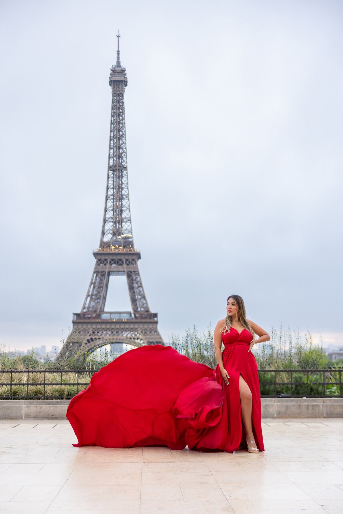 Un flying dress pastello con lo strascico lanciato in aria accanto alla Torre Eiffel — Glam In Paris